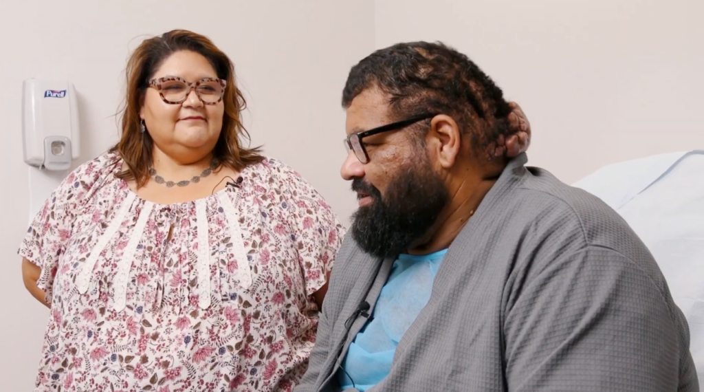 John sits beside his sister before surgery, surrounded by family support and hope for a new beginning.