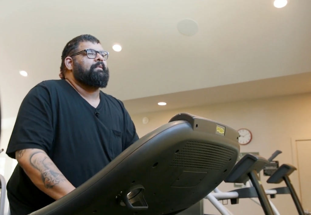 John walking on a treadmill after significant weight loss while preparing for acne keloidalis nuchae surgery.